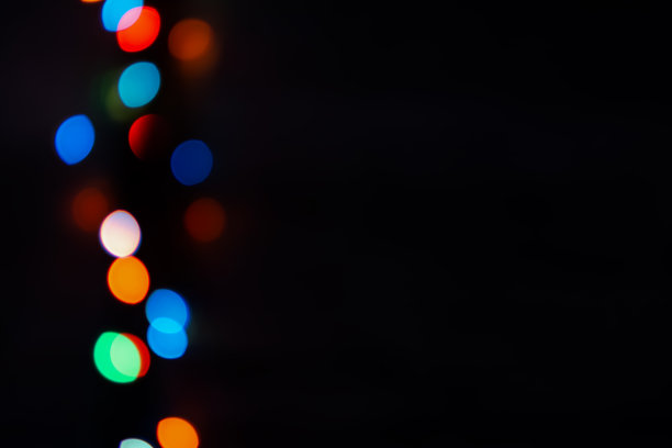 黑色背景上的多色散景。明亮模糊的节日灯光纹理。图片下载