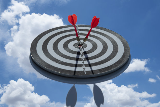 一个飞镖击中目标在一个红色的背景，概念为成功，飞镖运动模糊。图片下载