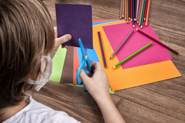 孩子在学校使用剪刀。佩戴防护口罩图片下载