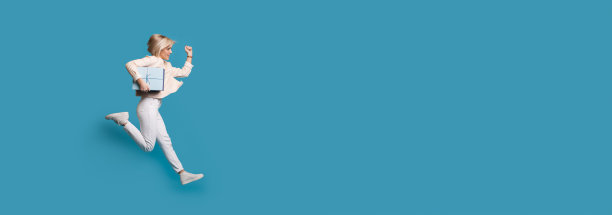 一个金发女人在工作室的墙上跑着，手里拿着一个礼物盒图片下载