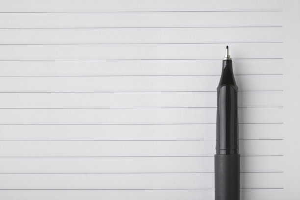 黄色背景上的空白笔记本和黑色钢笔的细节图片下载