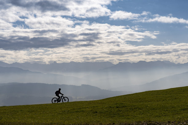 骑着电动山地车的女人可以看到布雷根茨瓦尔德山脉图片下载