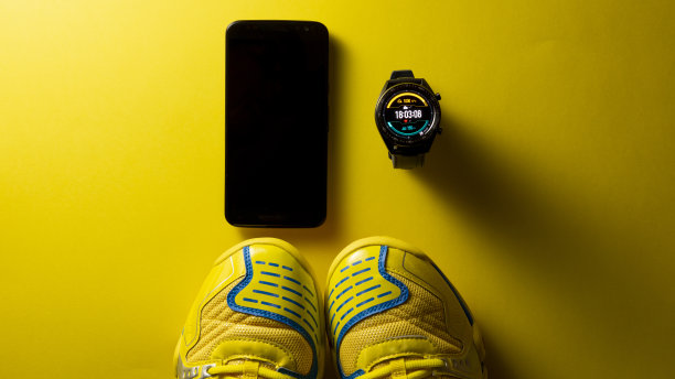 一个黑色智能手表的特写在一个金色的背景，类似于手表的脸。技术和优雅的概念。垂直的摄影。本空间图片下载