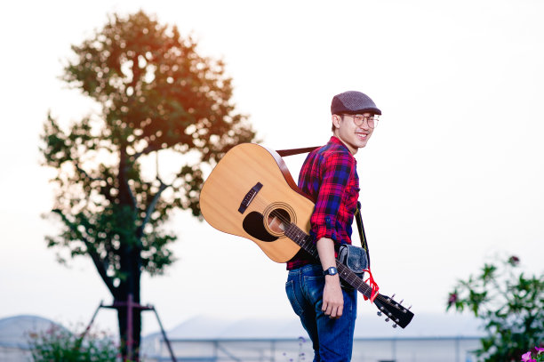 一个吉他手愉快地站在那里看着音乐的成功图片下载