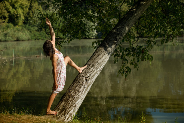 夏末，一个年轻漂亮的女人在公园里练习瑜伽。健康生活方式概念库存照片。图片下载