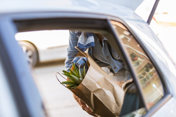 剪成女人在汽车后备箱里装购物袋的样子图片下载
