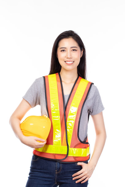有吸引力的美丽年轻的亚洲建筑女工在黄色头盔和反光背心摆孤立的白色背景。图片下载
