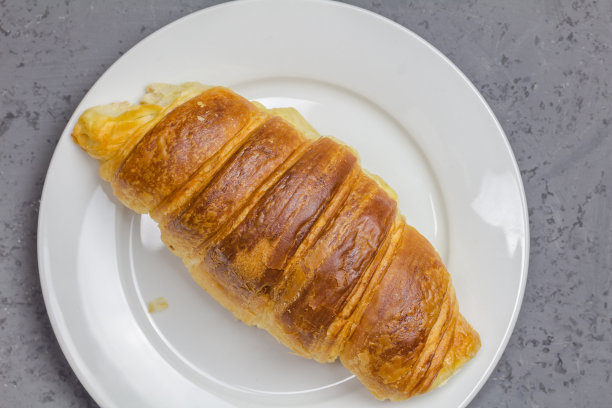 牛角面包在白色盘子与拷贝空间-俯视图近距离照片图片下载