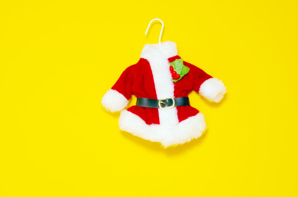 圣诞贺卡。黄色背景上的圣诞老人红衣服图片下载