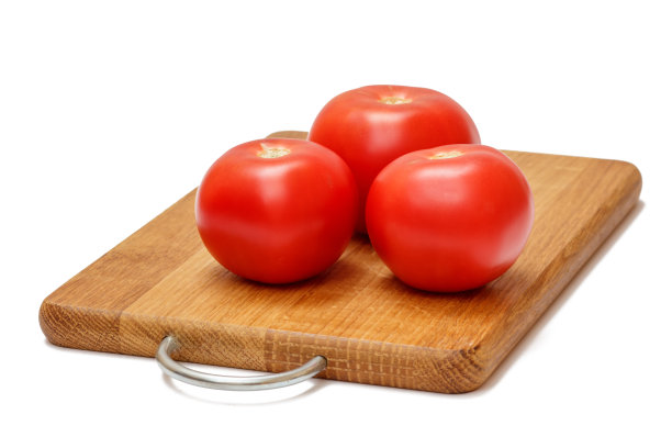 新鲜的红番茄放在木砧板上。图片下载