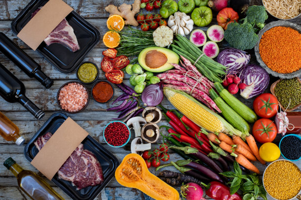 质朴的餐桌上放着真空包装的生牛肉和蔬菜。图片下载