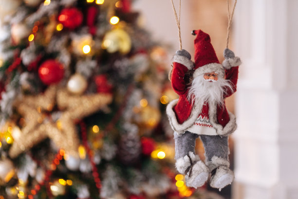 圣诞老人的玩具降落伞带来礼物在红色的圣诞树散焦的背景。大Copyspace概念新年横幅，海报。图片下载