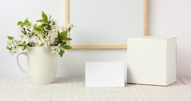 空的白色卡片和一个满是盛开的树枝的杯子。图片下载