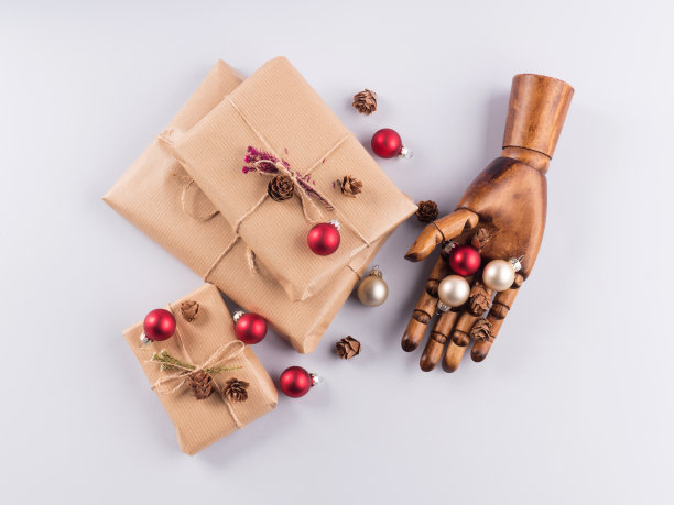 手拿包裹好的圣诞礼物和装饰品图片下载