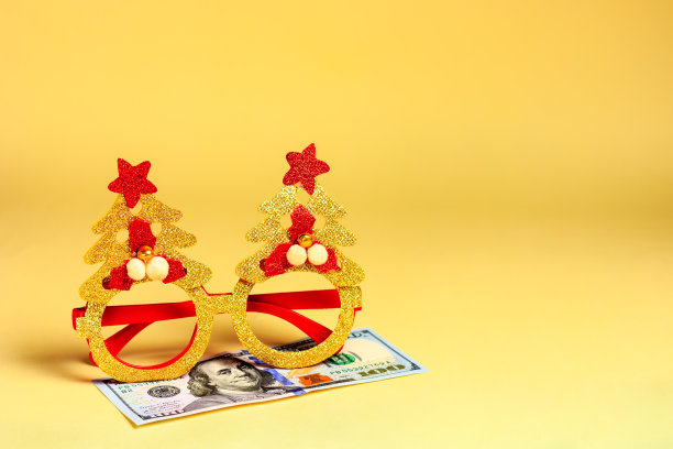 新年、圣诞节假面舞会的眼镜和钞票、美元——躺在黄色的背景上。对捐赠和礼物的敌意预算图片下载