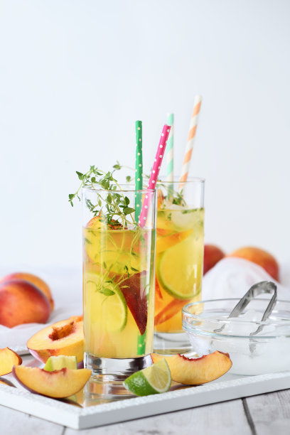 桃子夏季鸡尾酒。清新的有机无酒精饮料，柠檬水，成熟油桃，百里香和酸橙在一个玻璃杯图片下载