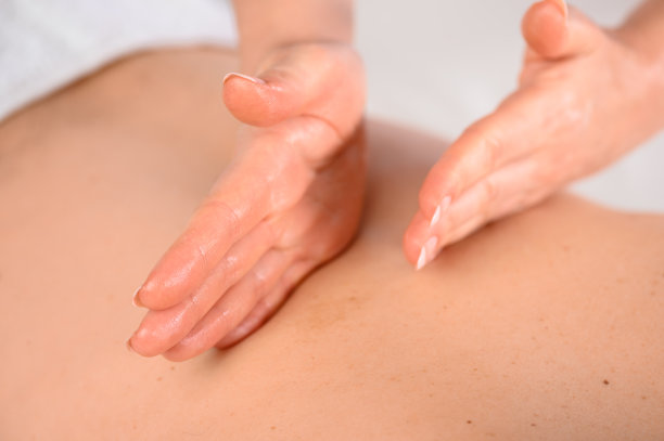 女人的双手用手掌的边缘在背部做按摩，非常近距离柔和轻。图片下载