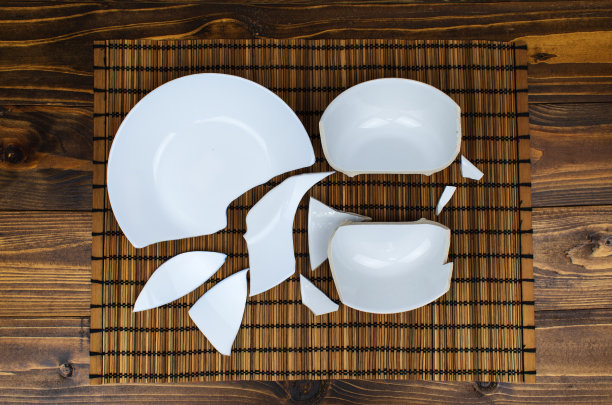 破碎的盘子。木桌上的碎盘子图片下载