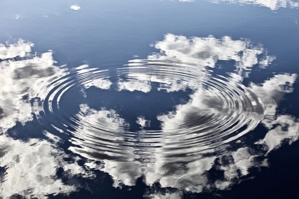 在平静的蓝色水面上美丽的发光的圆圈特写图片下载