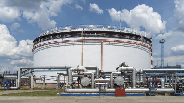 油库储罐。大型白色工业油箱的汽油和石油在经典的蓝天背景。石化的概念。图片下载