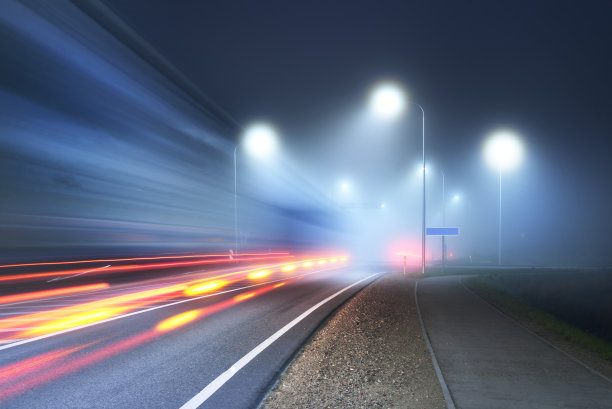 在大雾中照亮的新公路的全景。月光。黑暗的城市风光。欧洲。交通、物流、旅游、旅游、自驾游、自由、自驾。动态模糊效果图片下载