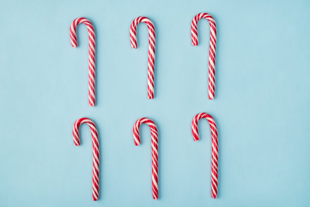 传统糖果的圣诞概念。顶部平躺近距离观察照片六个硬焦糖藤孤立的彩色背景图片下载