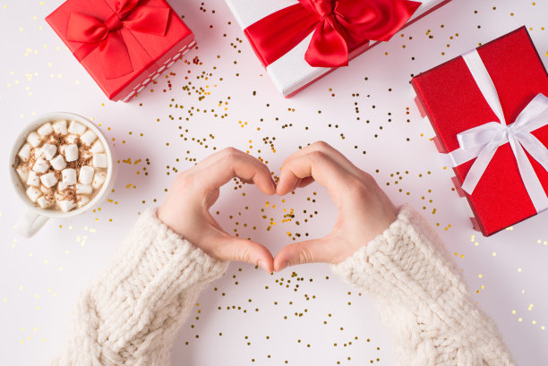 做我的情人节概念。头顶上的近距离观看照片的女性的手在白色的桌子背景显示心脏与丝带蝴蝶结包裹盒子图片下载