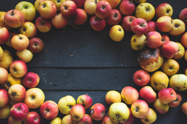 组合苹果在黑色木制背景，自然光照片，俯视图图片下载
