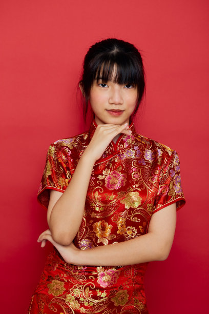 年轻的亚洲妇女穿着带有动作的旗袍迎接中国新年图片下载