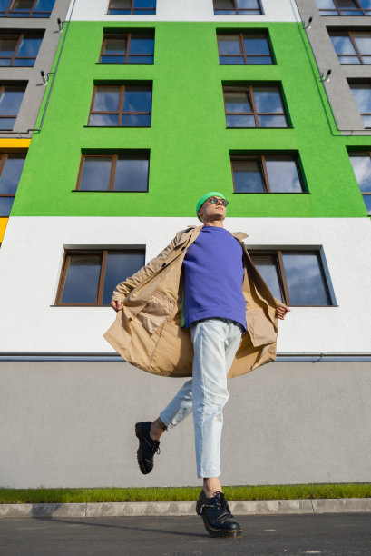 专业舞者穿着鲜艳的衣服在现代房子的背景上跳街舞图片下载