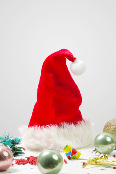 圣诞老人帽，圣诞和新年装饰品，纸屑，礼物盒和派对吹在桌子上。图片下载