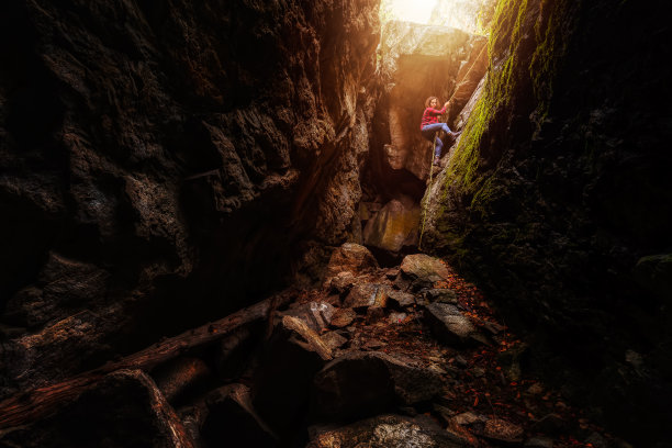 探险女孩正在下降进入岩石洞穴图片下载