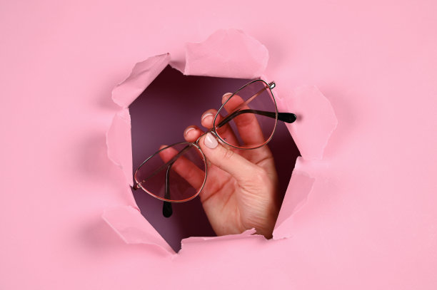 手持粉色背景的眼镜图片下载