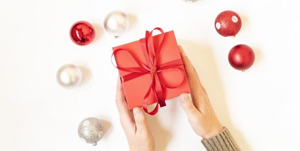 一个男人拿着圣诞礼物放在白色的桌子上素材图片