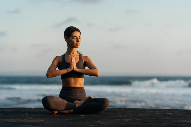 年轻女子在大自然中做瑜伽体式，海景。图片下载