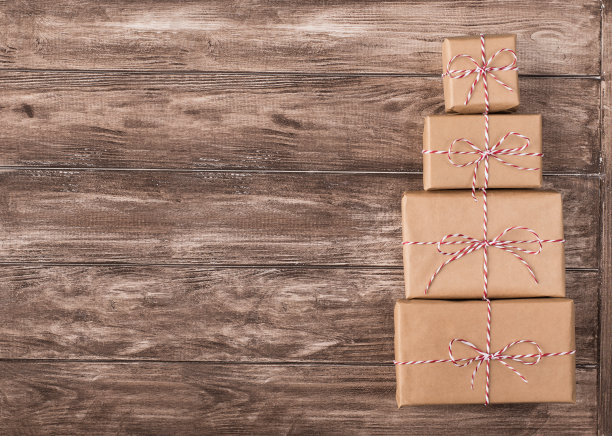 俯视图照片堆堆礼物盒包装在牛皮纸上木制棕色背景书桌桌子图片下载