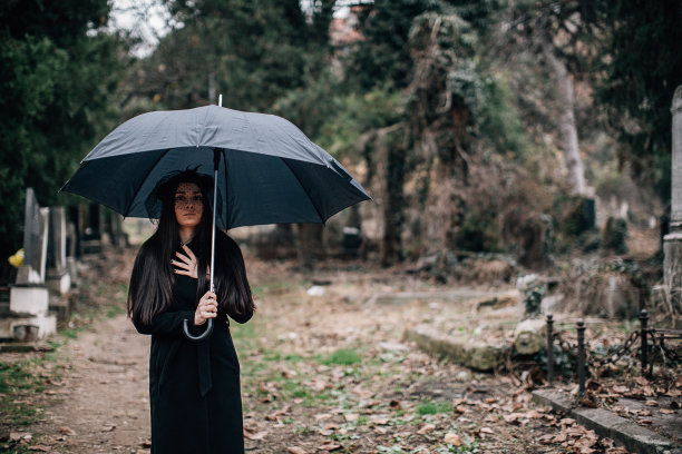 一个悲伤的女人去墓地看望亲人图片下载