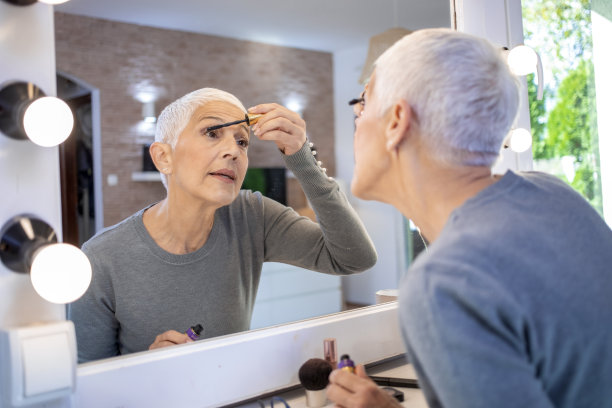 美丽成熟的女人看着镜子里的自己。图片下载