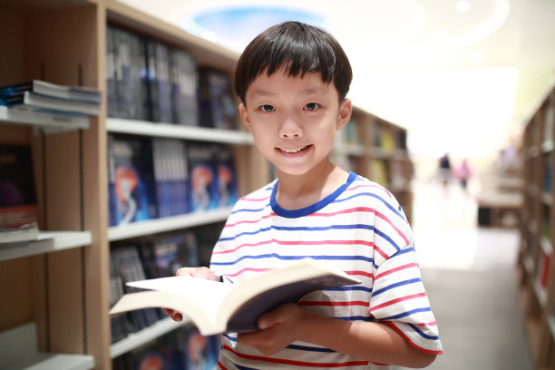 快乐的亚洲孩子在图书馆看书。图片下载