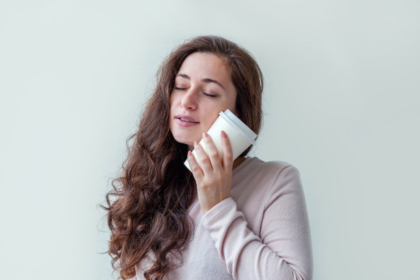 美丽年轻的黑发女人与带走的纸咖啡杯孤立在白色的背景。快乐微笑的女孩正在吃午饭。早上喝饮料休息休闲的概念图片下载