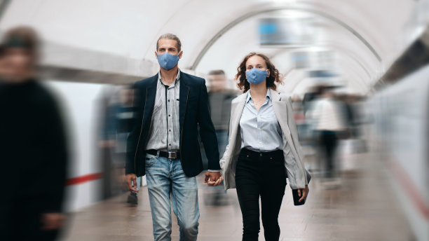 一对相爱的情侣穿过地铁里的人群图片下载