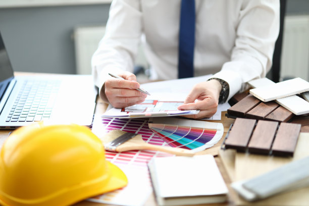 在办公室的设计师坐在桌子上与项目和室内调色板图片下载