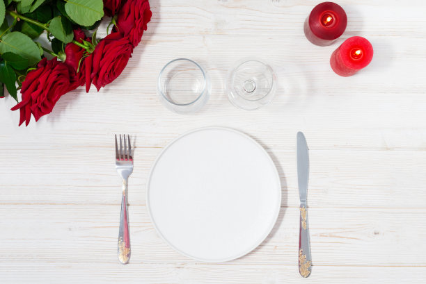 木桌上装饰着玫瑰花束和红蜡烛，营造出质朴的浪漫情调图片下载