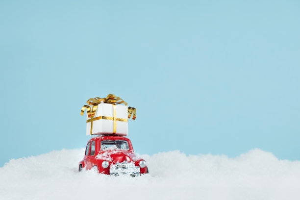 圣诞红色的车与一个礼物盒在蓝色的雪景。空间的文本。新年贺卡的概念图片下载