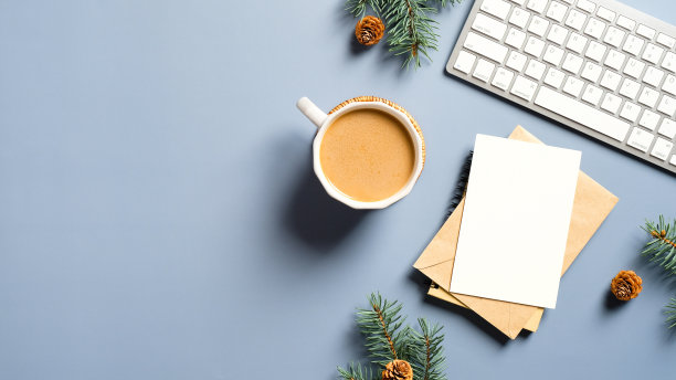 圣诞节装饰品，咖啡杯，键盘，纸质笔记本。平躺，俯视图。圣诞节的工作区。Hygge，北欧，简约风格。图片下载