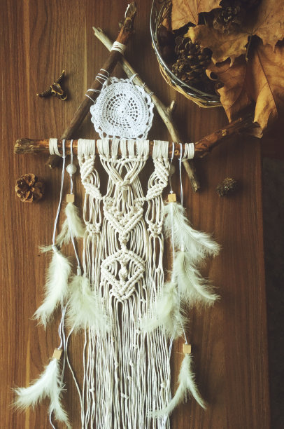 手工墙上挂着白色的羽毛。家居装饰的照片图片下载