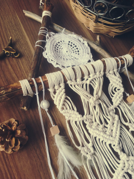 手工墙上挂着白色的羽毛。家居装饰的照片图片下载