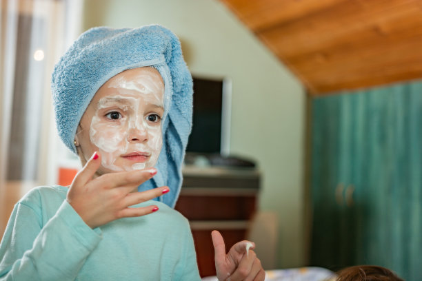 可爱的小女孩在镜子前涂面霜图片下载