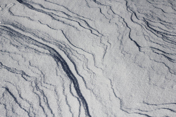 雪白的背景。雪的质地。闪亮的雪与散景和模糊的背景特写。白色的白雪覆盖的领域。雪景微距照片。图片下载