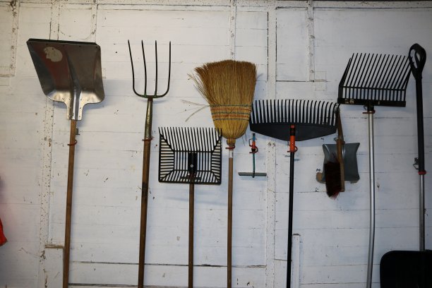 各种各样的园艺工具在墙上挂成一排图片下载